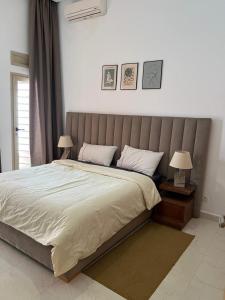 een slaapkamer met een groot bed met 2 lampen bij Appartement Élégant in Marrakesh