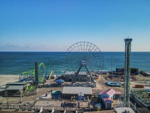 an amusement park with a ferris wheel next to the ocean at Sea Breeze Beach View in Seaside Heights
