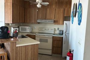 a kitchen with wooden cabinets and a white refrigerator at Sea Breeze Beach View in Seaside Heights