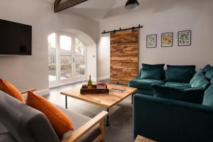 Chatton的住宿－The Steading at West Lyham，客厅配有绿色沙发和桌子