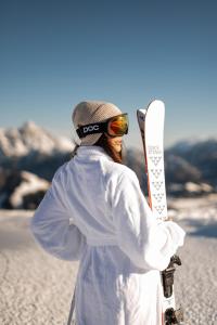 una persona sosteniendo una tabla de snowboard en la cima de una montaña en ADEA Lifestyle Suites Fieberbrunn, en Fieberbrunn