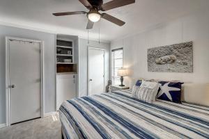 a bedroom with a bed and a ceiling fan at Blue Moon (Mustang Isle #11) in Port Aransas