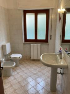 łazienka z toaletą i umywalką w obiekcie Casa Assunta w mieście Donoratico