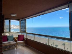 a room with a balcony with a view of the ocean at PRINCIPADO MARINA - Fincas Arena in Benidorm