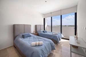 two beds in a bedroom with large windows at SIELA Oceanfront Luxury 4 BR Villa in San Bruno +21 photos