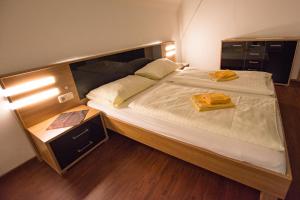 um quarto com uma cama grande com duas toalhas amarelas em Gästehaus Leypold em Murau