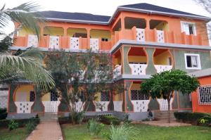 an orange building with trees in front of it at Château angele W&B in Lomé