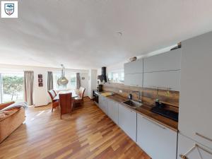Apartmant Alpin - Top 1 by Four Seasons Apartments في كابرون: مطبخ مع دواليب بيضاء وغرفة معيشة
