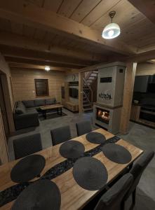 ein Wohnzimmer mit einem Holztisch und einem Kamin in der Unterkunft Domek Widokowy Tyniok in Koniaków