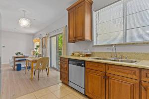 a kitchen with wooden cabinets and a table with a dining room at modern design home near disneyland in Fullerton