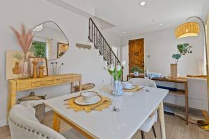 a dining room with a white table and chairs at modern design home near disneyland in Fullerton