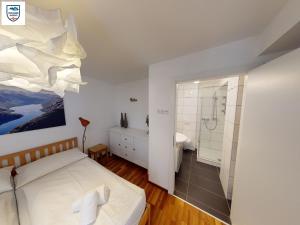 Apartmant Alpin - Top 1 by Four Seasons Apartments في كابرون: غرفة نوم بسرير وحمام مع دش