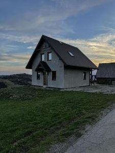 ein Haus auf einem Grashügel in der Unterkunft Domek Widokowy Tyniok in Koniaków