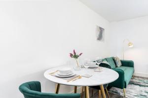 a living room with a white table and green chairs at Exclusive One Bedroom Apartment - City Centre - Free Wi-Fi Netflix in Sheffield