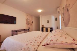 a bedroom with a white bed with pillows on it at Dubrovnik Airport Apartment Pascal in Močići