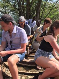 Un gruppo di persone sedute su un tronco d'albero di Real African Life safaris and Camps a Lukungu