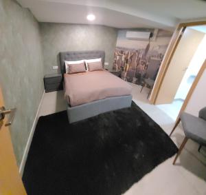 Habitación pequeña con cama y alfombra negra en Hostal Bo Camiño, en Porriño