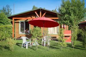 a red umbrella and chairs in front of a cabin at Cabañas Buenavista Quillón in Quillón
