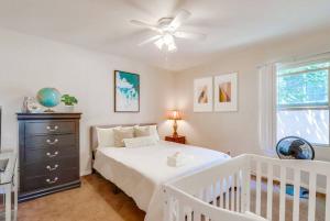 a white bedroom with a crib and a ceiling fan at Entire Private Cozy 3-Bedroom House, 10 mins San Diego Gaslamp in National City