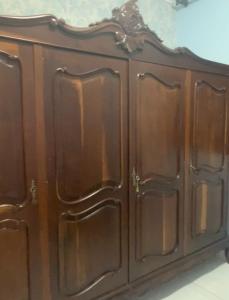 a wooden cabinet with brown doors on top at Casa de aluguel mobiliada in Sarandi