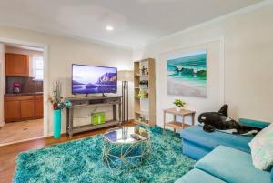 a living room with a blue couch and a tv at Entire Private Cozy 3-Bedroom House, 10 mins San Diego Gaslamp in National City