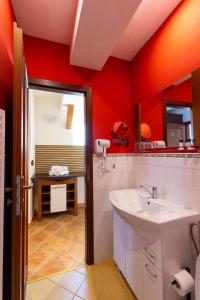 baño con paredes rojas y lavabo blanco en Apartmán v centru en Česká Lípa