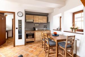 a kitchen with a wooden table and chairs at Apartmány v centru in Česká Lípa