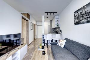 STAR stylish flat in a modern neighborhood في براتيسلافا: غرفة معيشة ومطبخ مع أريكة وطاولة