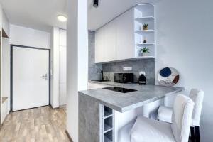 a kitchen with white cabinets and a counter at STAR stylish flat in a modern neighborhood in Bratislava