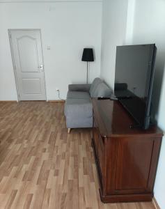 a living room with a television on a dresser and a couch at Christie's 3 central apartment to Bucarest in Bucharest