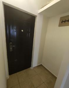 a black door in a room with a tile floor at Christie's 3 central apartment to Bucarest in Bucharest +2 photos