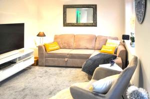 a living room with a couch and a television at The Sashes - Apartment One - FREE Parking - Ultrafast WIFI - Smart TV - Netflix - sleeps up to 6! Close to Poole Town Center & Sandbanks & Bournemouth in Poole