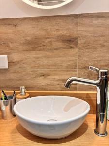 een witte wastafel in een badkamer met een houten wastafel bij Ruhig & Gemütlich Nahe Frankfurt in Neu Isenburg