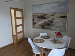a dining room with a white table and chairs at Ferienwohnung am Nordstrand in Alt Schwerin