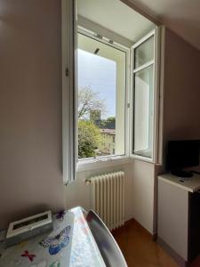 una ventana en una habitación con un ordenador en una mesa en Appartamento Ai Crotti, en Dervio