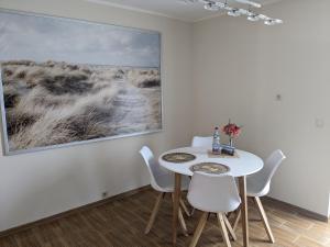 a dining room with a table and chairs and a painting at Ferienwohnung am Nordstrand in Alt Schwerin