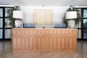 two laptops sitting on top of a wooden reception desk at Hotel Sa Punta - Adults Only in Begur