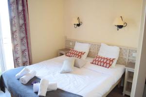 Un dormitorio con una cama blanca con almohadas rojas y blancas en Mazet Castel in Pont-Royal en Mallemort