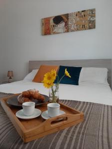 una bandeja con dos tazas y un plato de comida en una cama en Villa Luigi, en Arenella