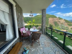 eine Terrasse mit einem Tisch und Stühlen auf dem Balkon in der Unterkunft Fuays Villa Premium in Trabzon