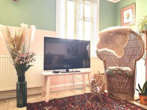 a living room with a tv and a chair and a table at Vibrant Urban Retreat in Camberwell in London