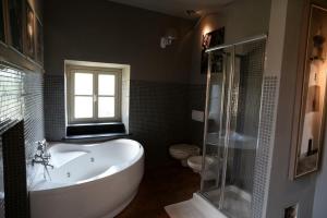 baño con bañera, aseo y ventana en Villa Margherita appartamento per 5 in Villa ottocentesca, en Castiglione Chiavarese