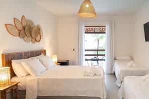 a bedroom with two beds and a window at Casa Dela Pousada in Cabo Frio +62 photos