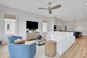 a living room with a white couch and blue chairs at Lil' Nauti in St. George Island