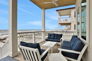 Un balcón con sillas, una mesa y el océano en Lil' Nauti en St. George Island