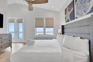 a bedroom with a large bed with a ceiling fan at Lil' Nauti in St. George Island