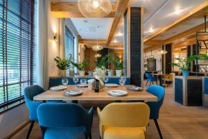 een eetkamer met een grote houten tafel en blauwe stoelen bij Hotel Badura in Wadowice