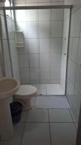 y baño blanco con ducha y aseo. en Suítes na Barra da Lagoa, en Florianópolis