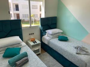 1 dormitorio con 2 camas y ventana en Appartement Bousaid, en Oualidia