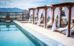 a hotel swimming pool with white drapes and a view at Flat Diamond 908 in São Lourenço